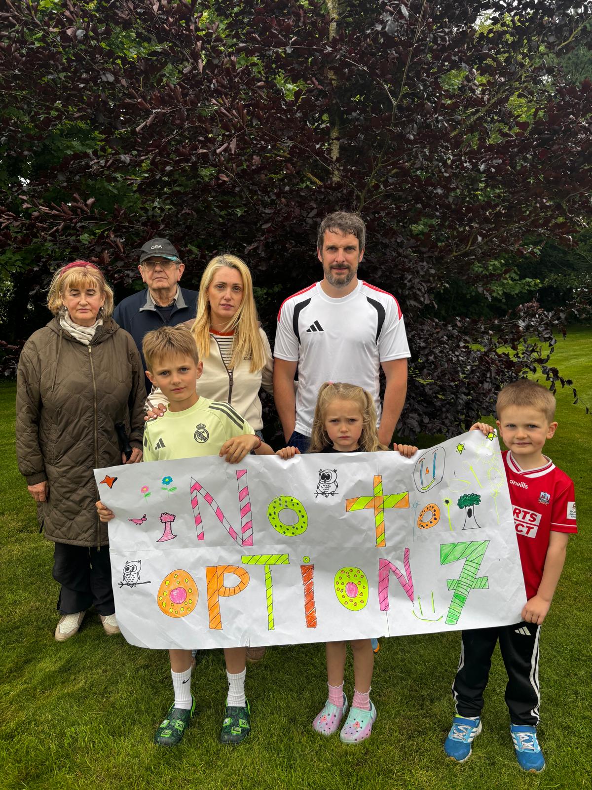 Family holding No to Option 7 banner